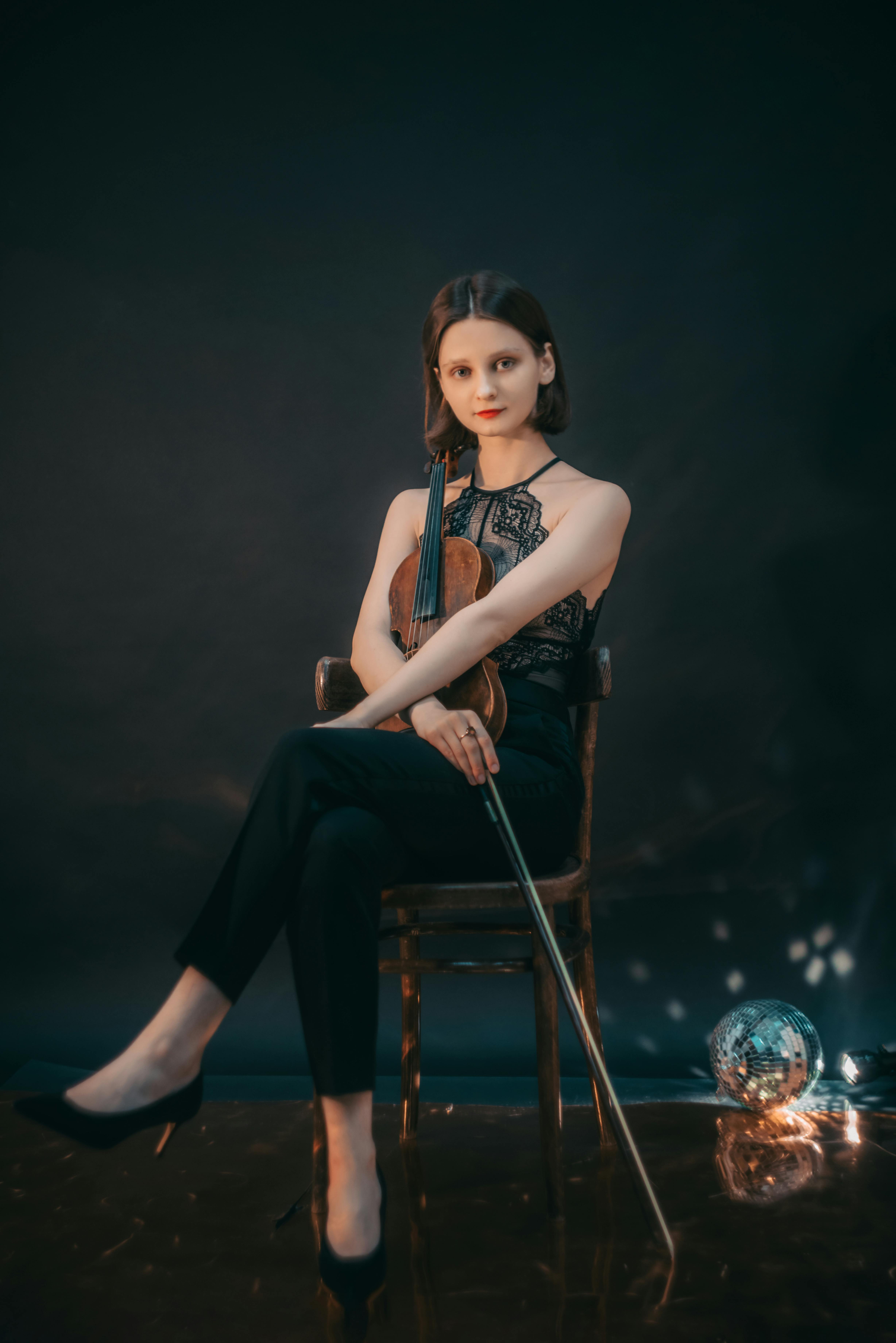 woman in a black top holding her wooden violin