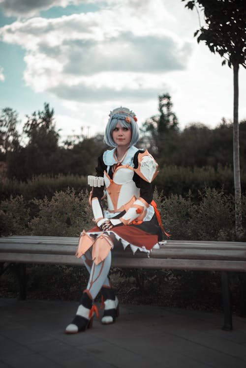 Photograph of a Woman in a Costume Sitting on a Bench
