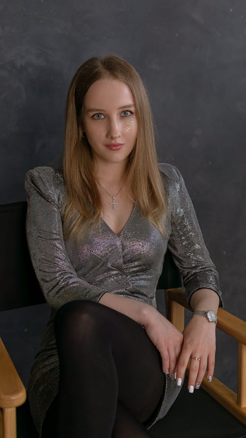 Woman in Gray Long Sleeve Dress Sitting on an Armchair 