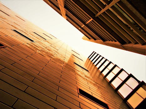 低角度视角下的现代建筑，玻璃外墙映照着温暖的光芒