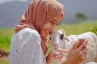 Woman in White and Blue Floral Robe Holding White and Brown Short Coated Dog