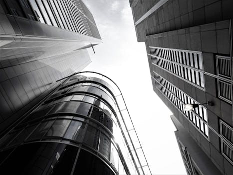 城市环境中，现代摩天大楼的玻璃外墙和钢结构呈现低角度视图