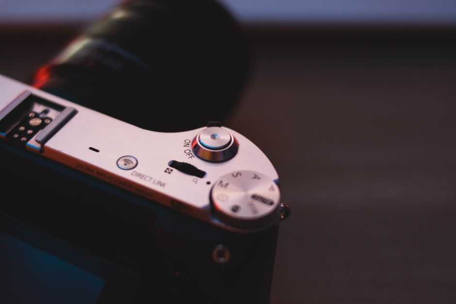 Detalhe da objetiva e controles da Panasonic L10 sobre mesa de madeira