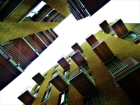 Low angle view of modern building with balconies and glass windows against a clear sky.