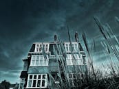 低角度镜头以喜怒无常的视角，捕捉了戏剧性天空下被高草环绕的经典建筑