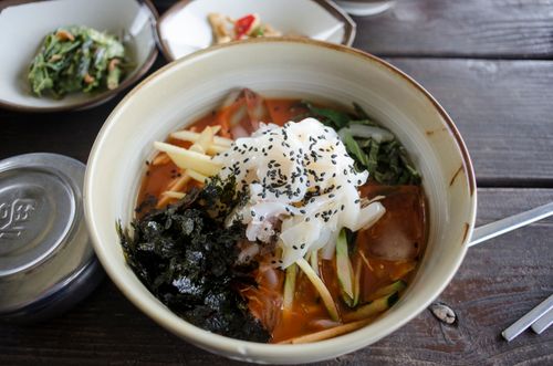 Free Scrumptious bowl of Asian seafood soup with fresh vegetables and nori, garnished with sesame seeds. Stock Photo