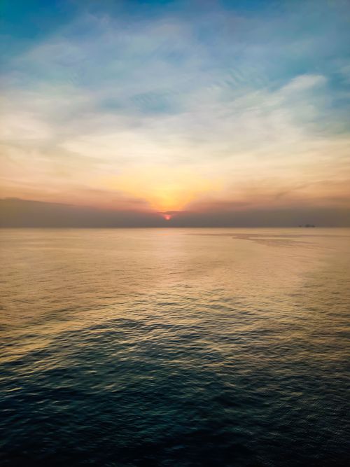 Free Beautiful ocean horizon during sunset with vibrant sky hues. Stock Photo