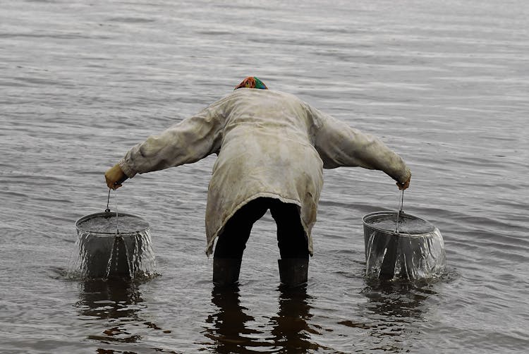 A Person Carrying Buckets Of Water