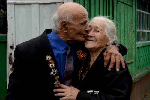 Photograph of an Elderly Man Kissing an Elderly Woman