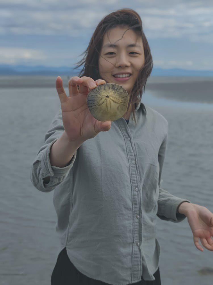 Girl On Beach Showing Skeleton Of Sea Urchin