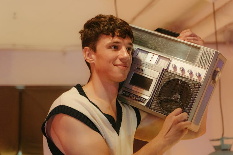 Photograph Of A Boy Holding A Boombox