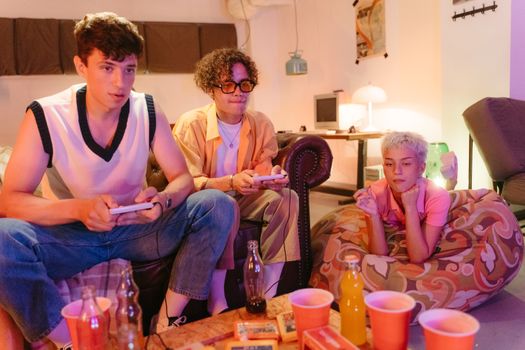 A group of three young adults playing video games indoors, creating a cozy and fun atmosphere.