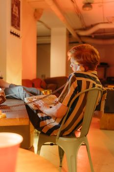 A relaxed indoor office scene features a man with a striped shirt using a phone.