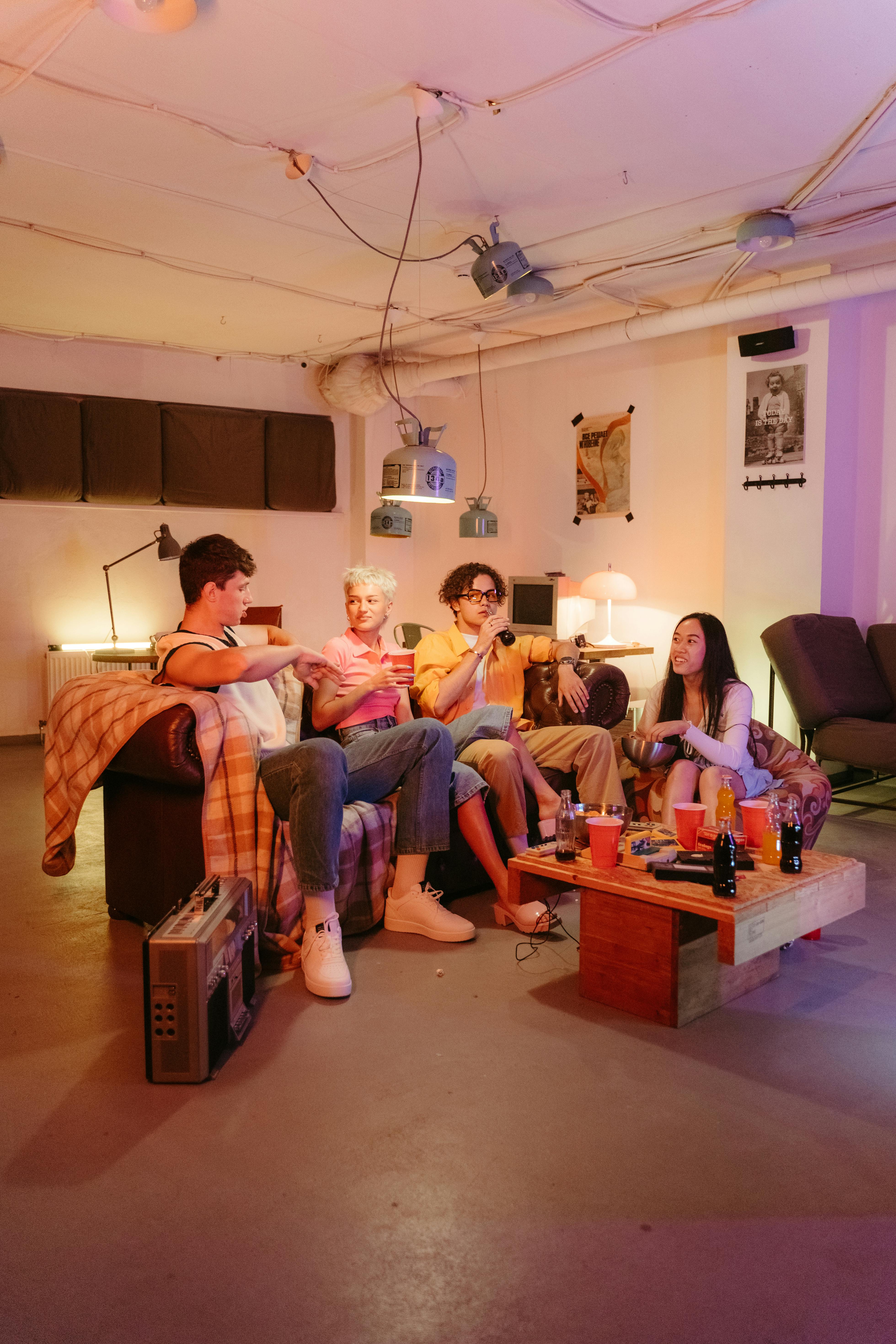 A group of young adults having fun and socializing in a cozy basement setting.