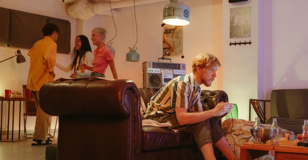 a group of diverse people sitting in a living room, talking and laughing, with journals visible on their laps