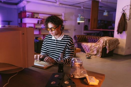 Teen enjoying a vintage gaming experience indoors, highlighting nostalgia and retro vibes.
