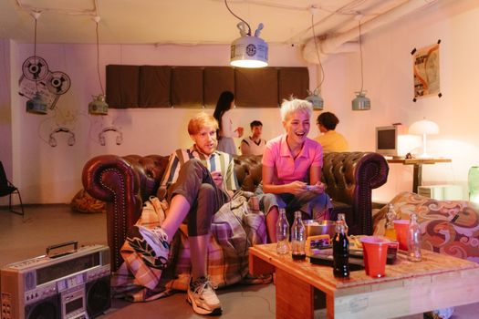 Friends enjoying a retro gaming night, with vintage decor and relaxed atmosphere.