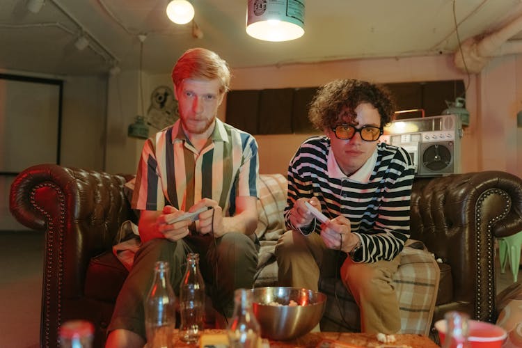 Friends Playing Video Game While Sitting On The Couch