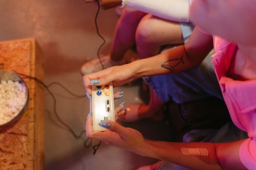 Close-up of hands holding a retro gaming controller, capturing the excitement of video gaming.