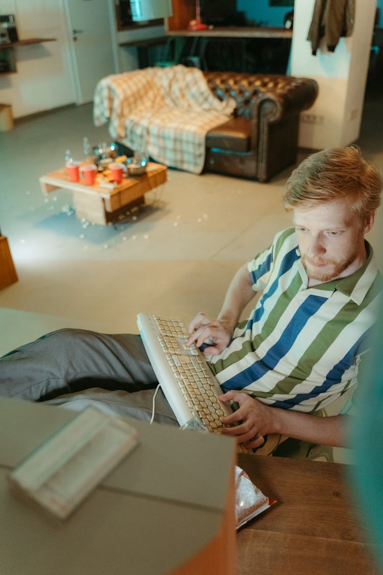 Man Using A Vintage Keyboard And Looking At A Computer Screen 