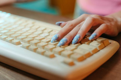 Person Typing on White Computer Keyboard