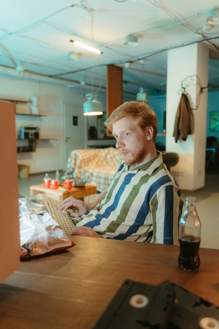 Man Wearing A Striped Shirt Typing On Keyboard