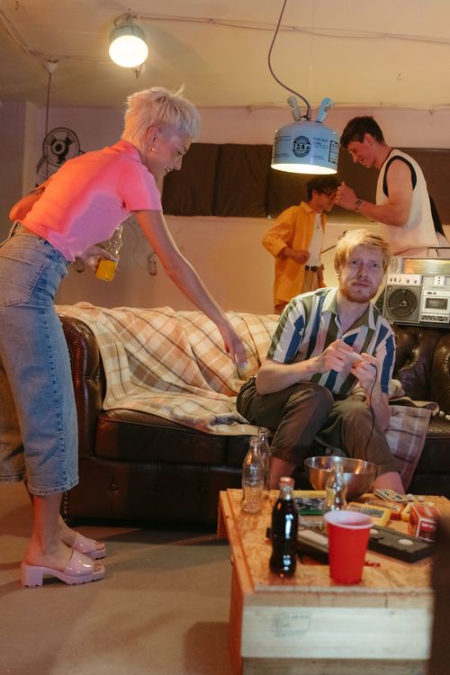 Free Teenagers having fun at a retro-themed house party with drinks and music. Stock Photo