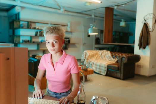 Teenager in a retro setting using an old computer with a soft drink on the desk.
