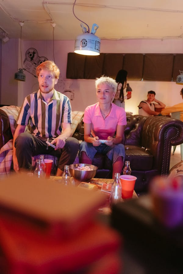 Man in Purple Dress Shirt Sitting Beside Woman in Pink Dress