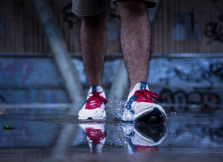 A Person Stepping On A Puddle Of Water