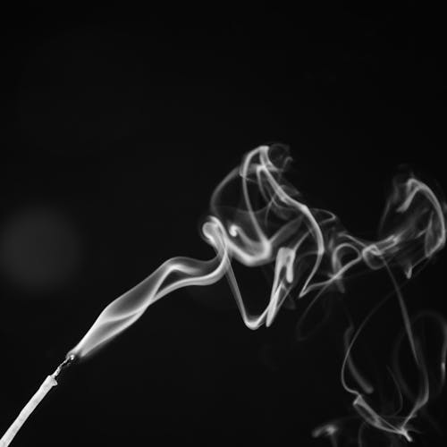 An Incense with White Smoke in Close-Up Photography