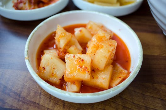 Delicious close-up of spicy radish kimchi served in a white bowl, perfect for Korean cuisine lovers.