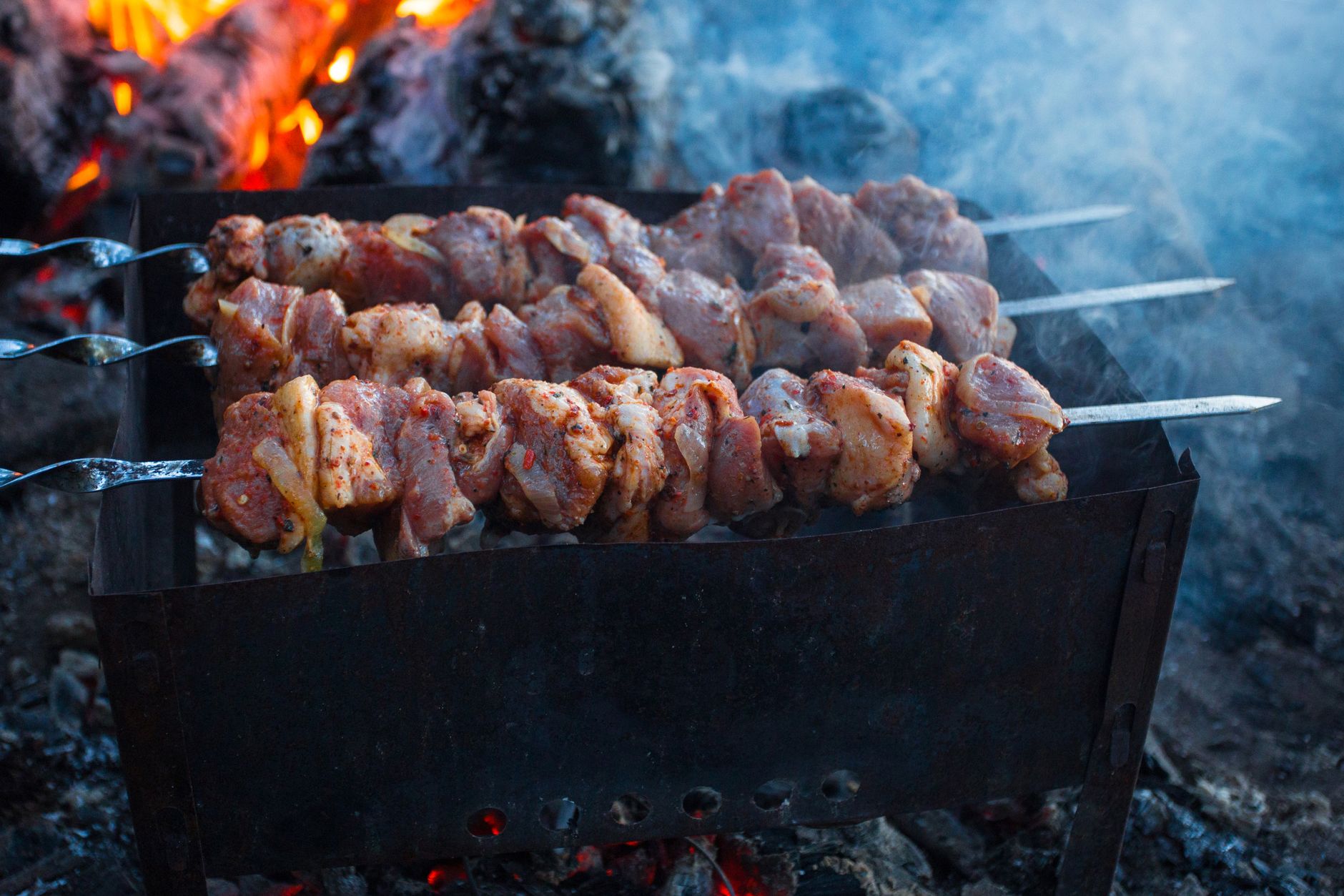 Campfire with seasoning sprinkled on grilled meat