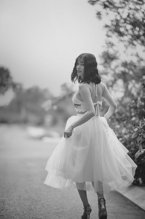 Grayscale Photo of Woman in White Dress Looking Back