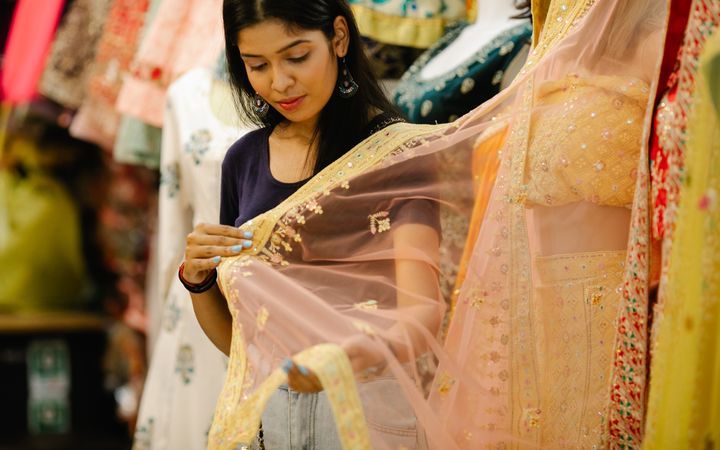 A young woman choosing a saree in a boutique