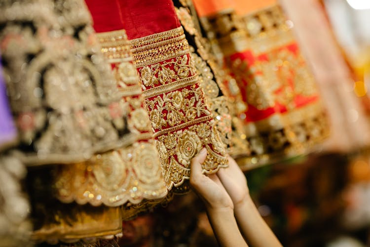 A Person Holding A Red Embroidered Fabric