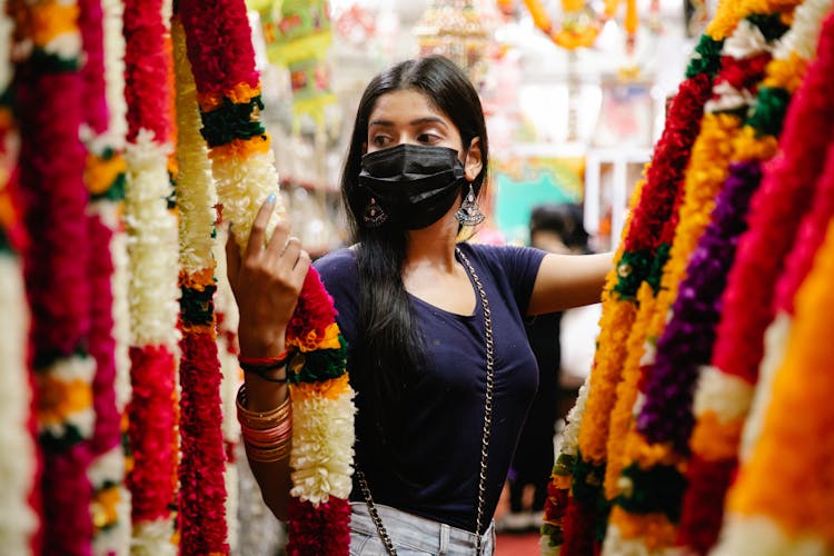 Woman In Face Mask Choosing Traditional Flowers Decorations