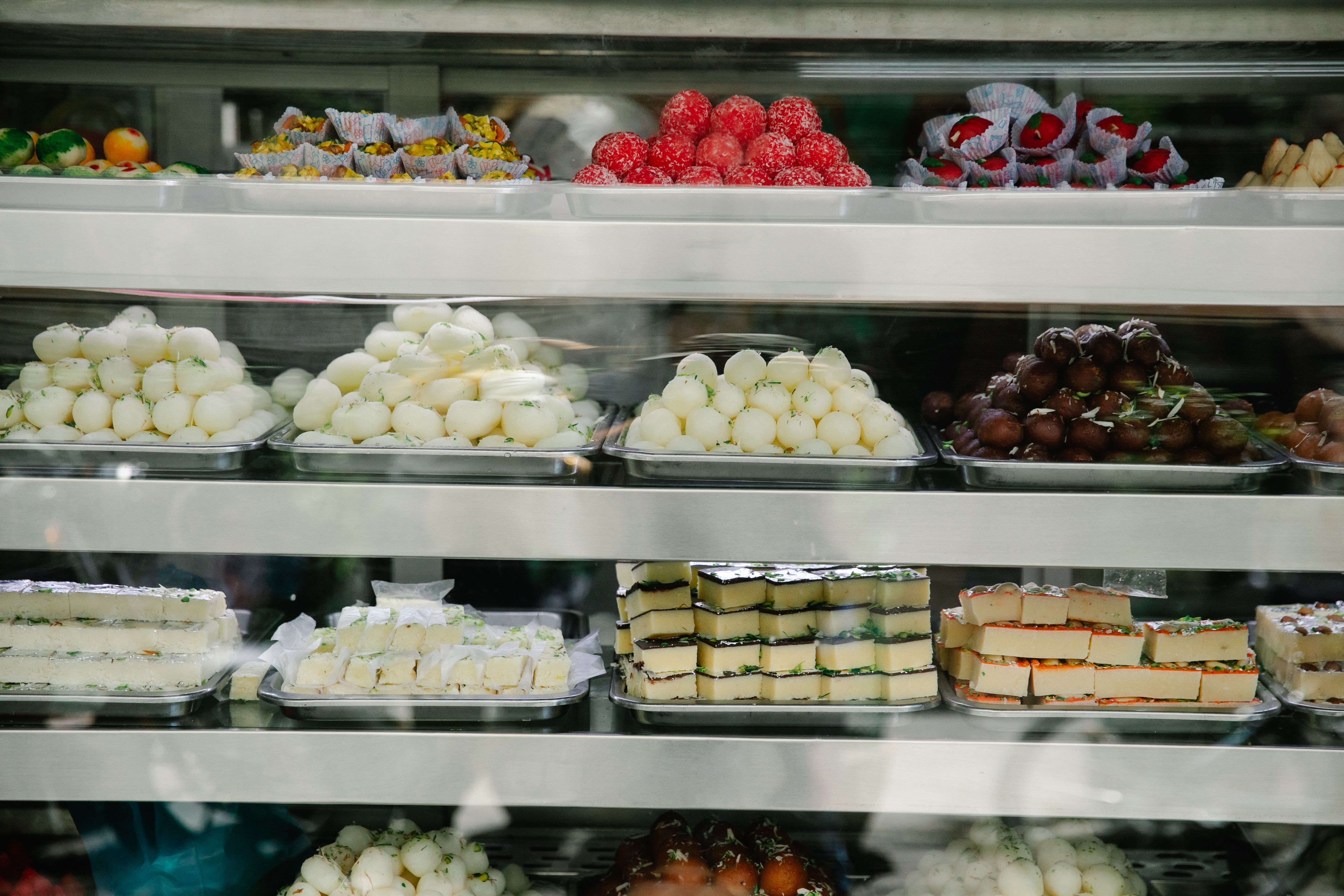 Tray of Punjabi mithai including pinni, barfi and jalebi at a sweet shop