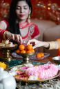 A Woman in Red Dress Touching an Orange Round Food