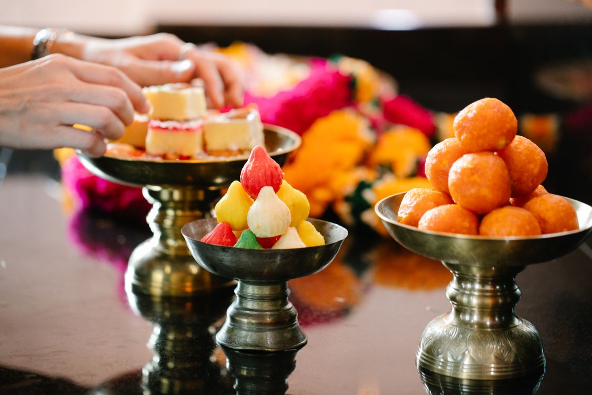 Colorful Indian sweets on brass platters, ideal for traditional celebrations.