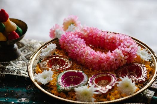 Elegant arrangement of flowers and decorative items on a traditional plate, perfect for cultural festivals.
