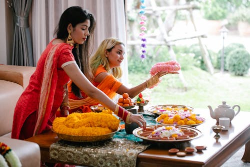 Women Wearing Sari Preparing Flower Necklaces and Traditional Snacks