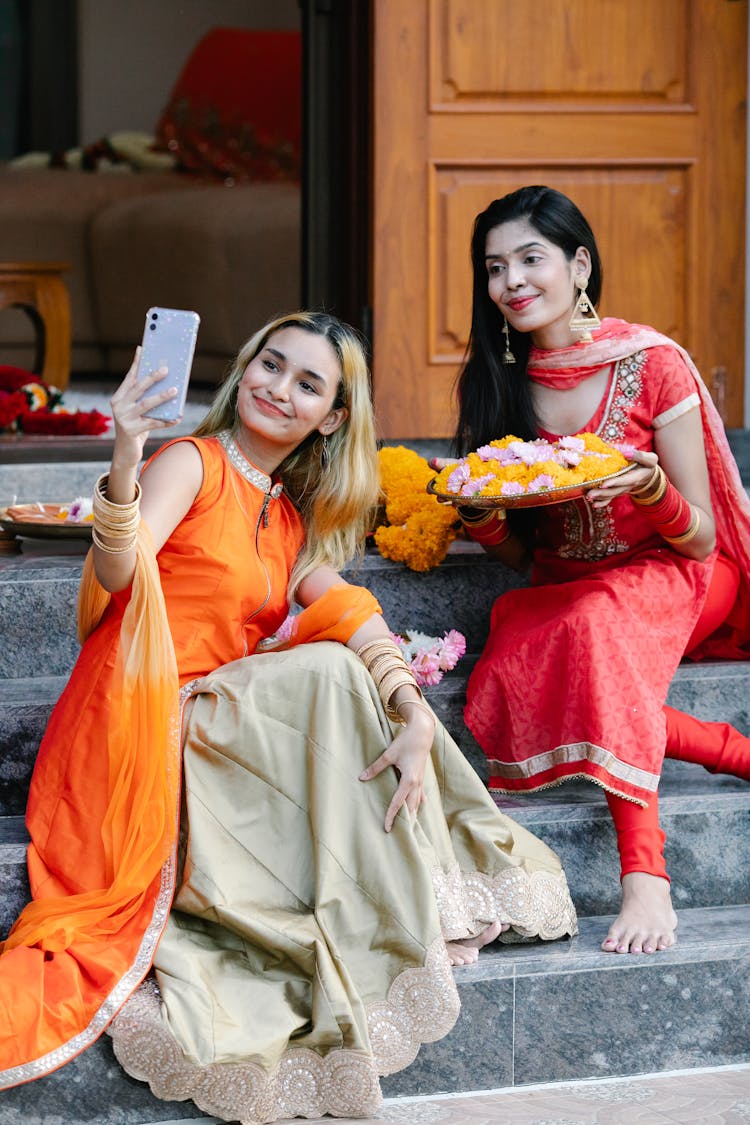 Two Girls In Traditional Dresses Posing For Selfie