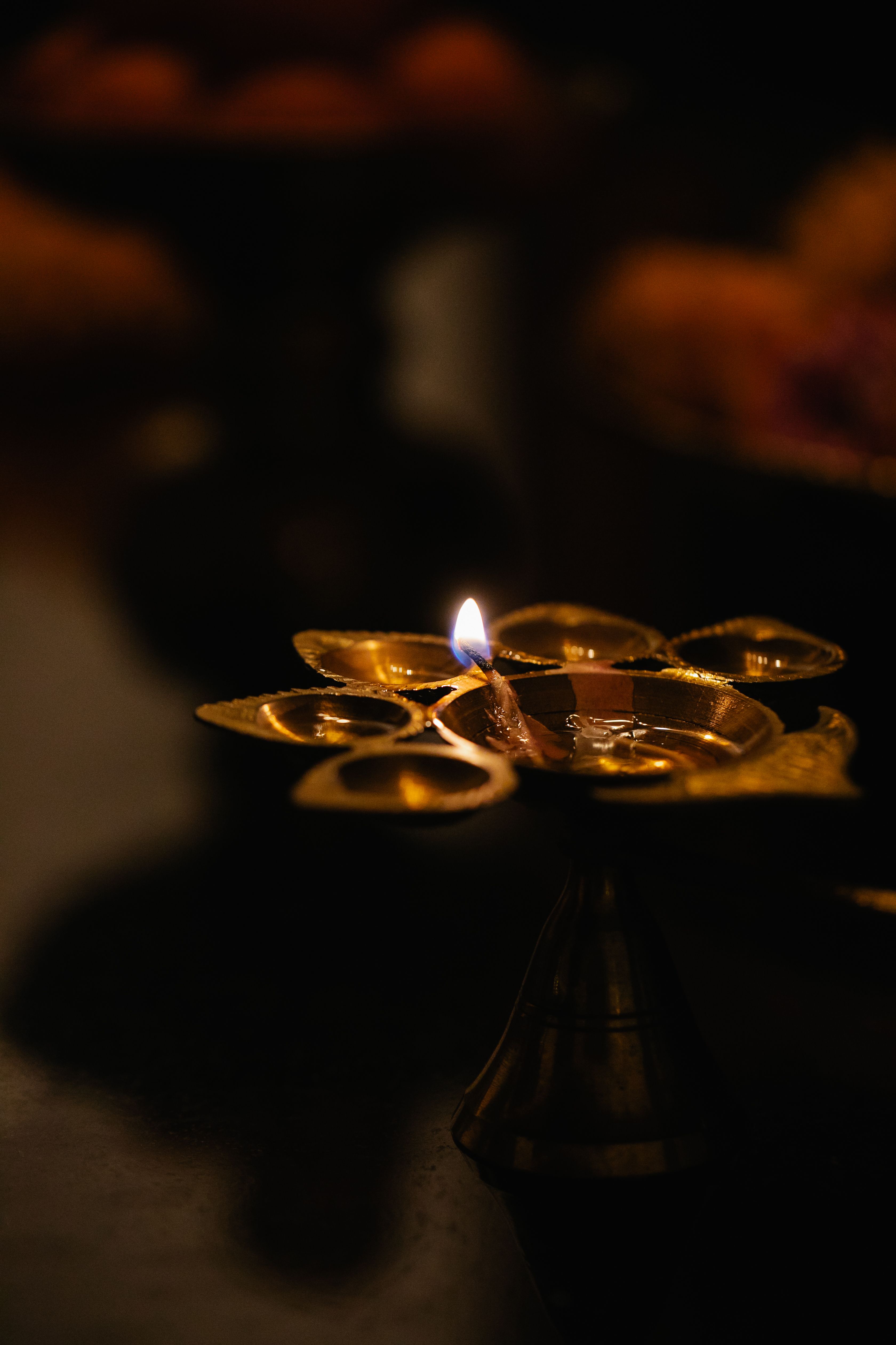 A brass oil lamp with a flickering flame symbolizes tradition and ritual.
