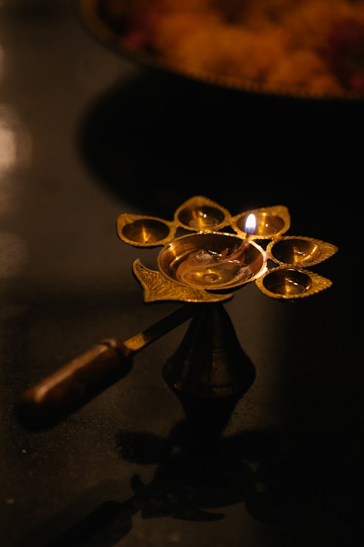 A Gold Candle Holder With Melting Candle
