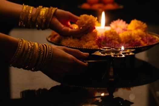 A Person Holding a Flower on a Tray with Candlelight