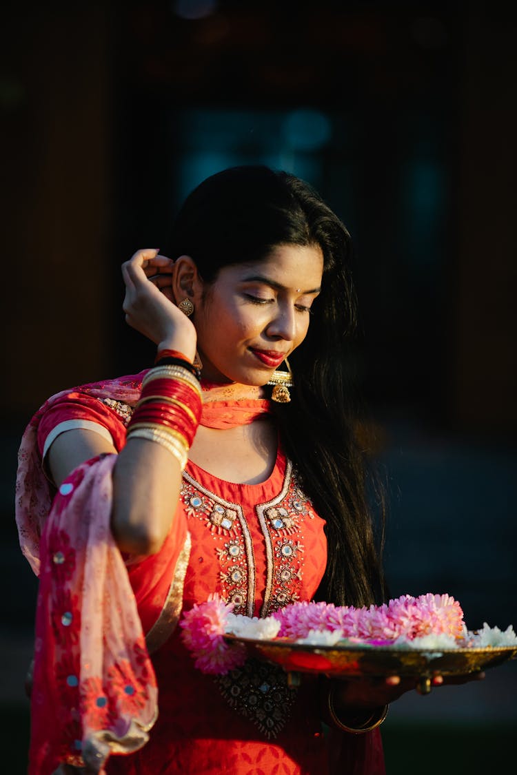 Woman In Traditional Dress With Plate With Flowers