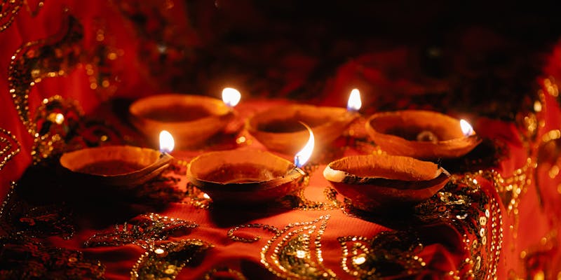 Traditional oil lamps on red and gold fabrics for ceremony