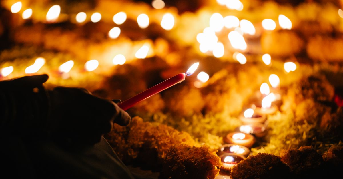 Warm, glowing candle ceremony highlights a hand lighting candles, depicting tranquility.