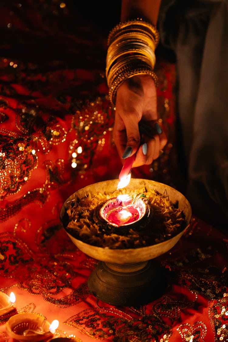 Close-up Of Woman Lighting Candle For Ceremony